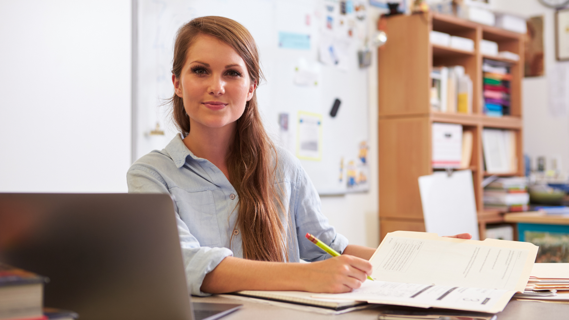 Educator sitting at desk with materials in front of her