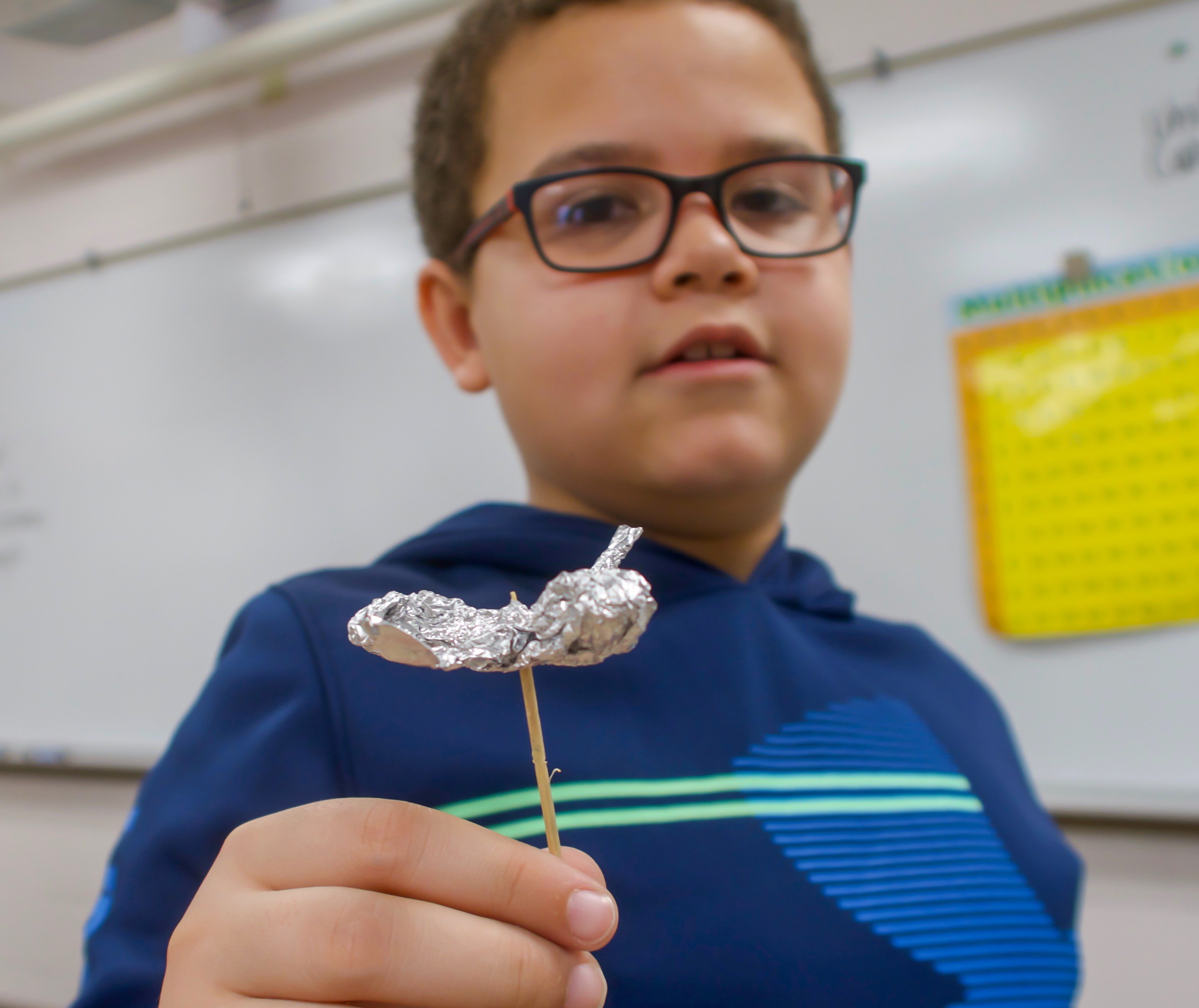 Student shares model of airplane made from aluminum foil.